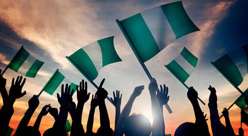 Silhouette of crowd holding Nigerian flags